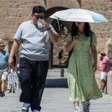 Des touristes se protègent du soleil lors d'une visite à Valence, en Espagne. KEYSTONE/EPA/MANUEL BRUQUE